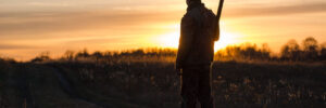 Hunter in backlight. Hunter at sunset. The shadow of the hunter. The man in the field.